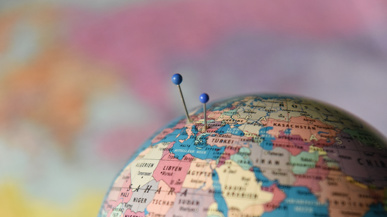 Weltkugel mit 2 Stecknadeln als Symbol für die Auslagerung