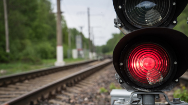 Rote Ampel mit Bahngeleisen im Hintergrund