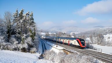 SBB Zug faehrt im Winter durch den Schnee