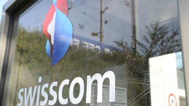 Das Logo der Swisscom an einer glas Fassade