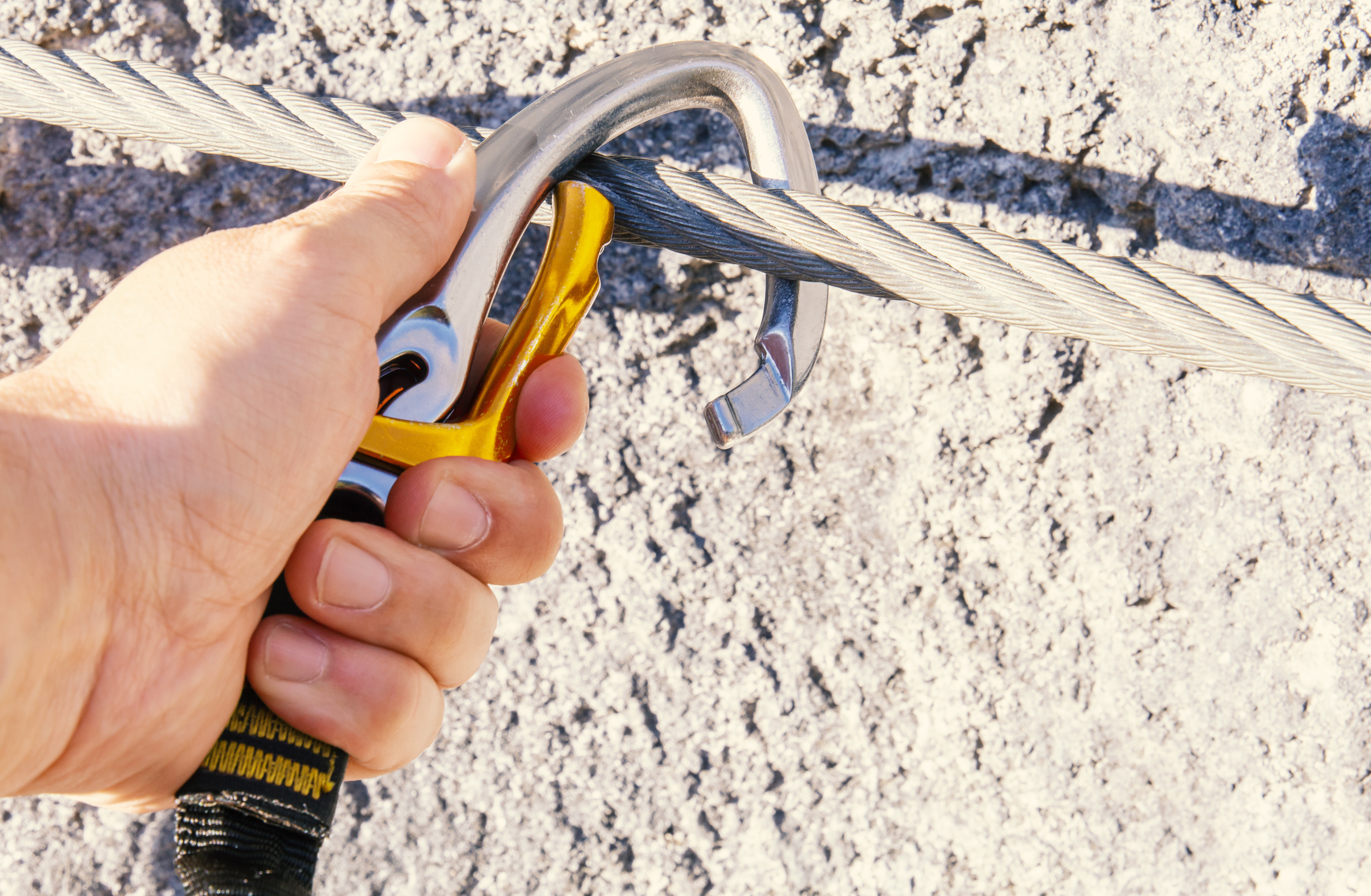 Jemand, der sich mit einem Karabiner sichert