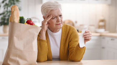 ältere Frau erschrocken über teuere Lebensmittelpreise