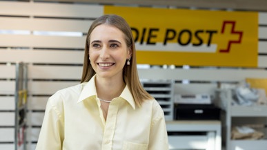 Eine junge Frau am Postschalter