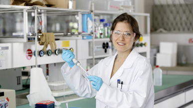 Eine Frau die in einem Labor ist und lächelt