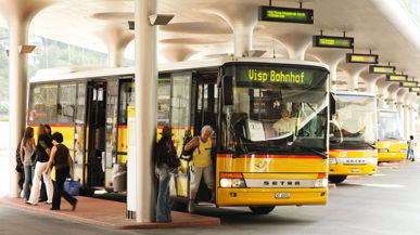 Eine grosse Haltestelle für Postautos in der Haltestelle stehen 5 Postautos nebeneinander