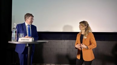 Bundesrat Rösti und Greta Gysin stehen sich gegenüber und diskutieren über die kritischen Fragen