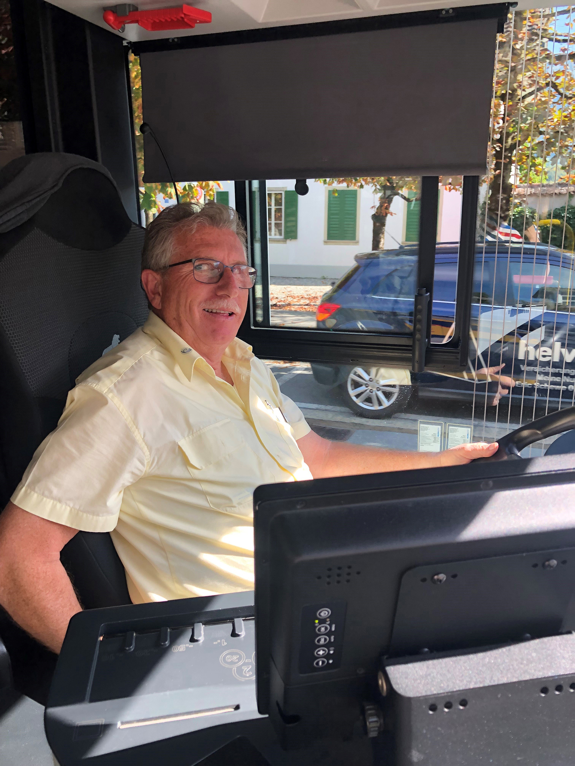 Ein Postauto von grünen Wiesen umgeben